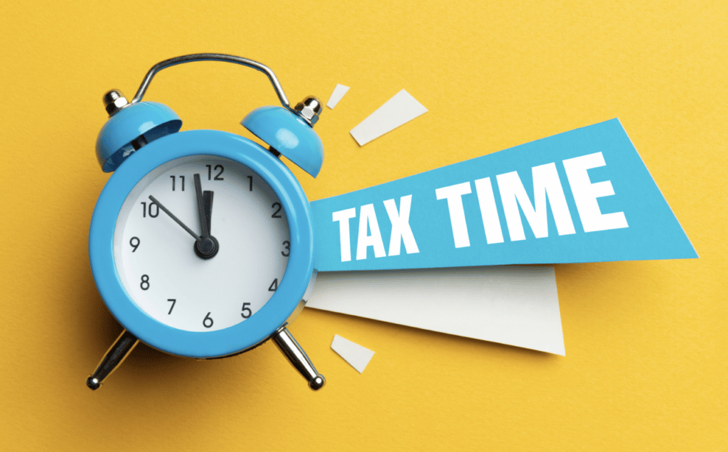 Tax time: blue alarm clock on yellow back ground